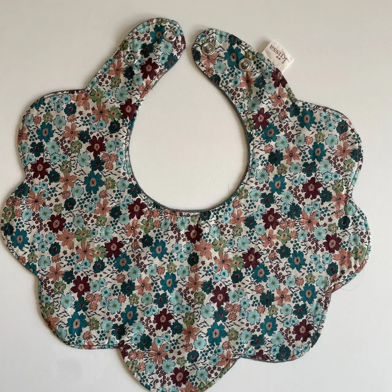 A floral bib photographed in soft daylight
