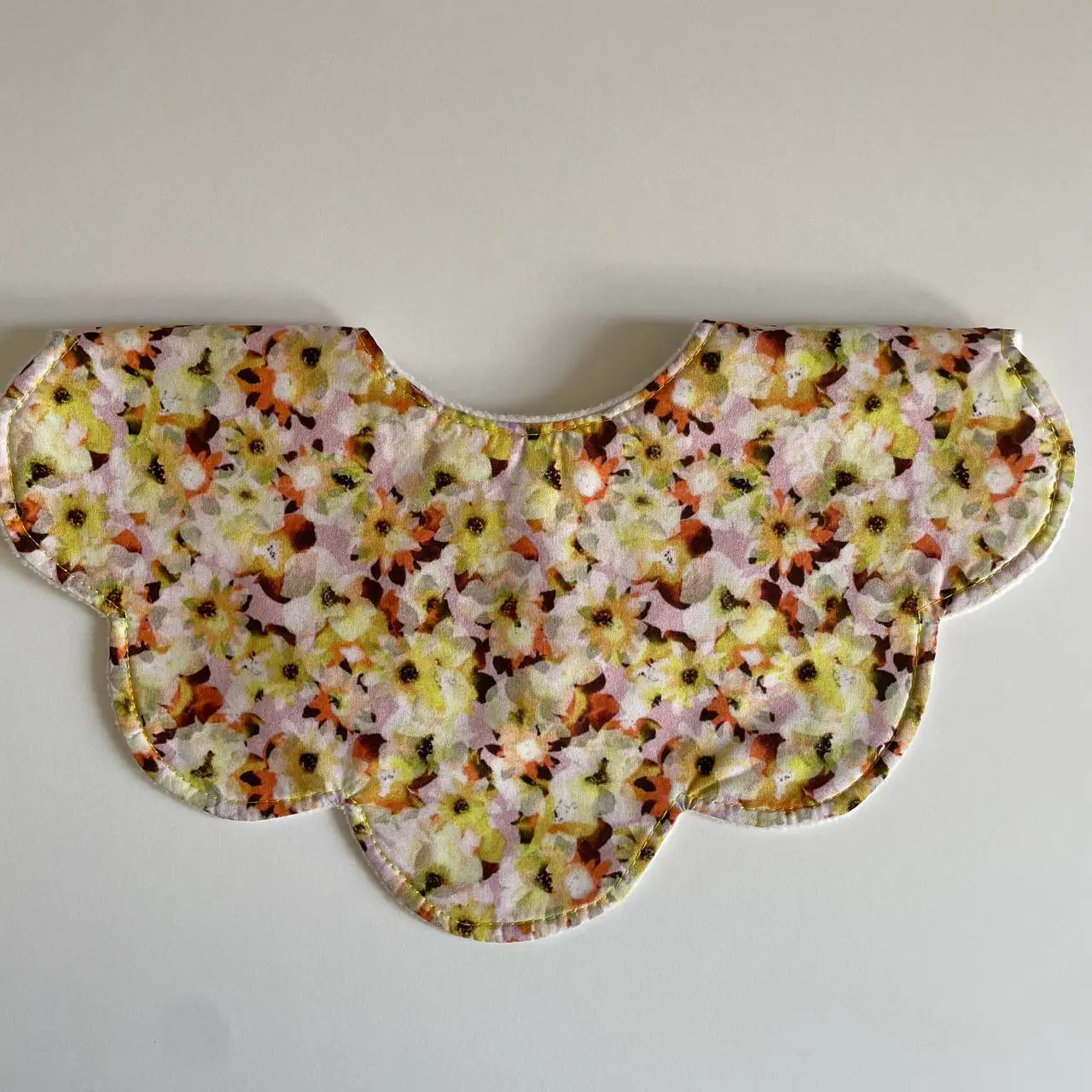 A scalloped collar piece in yellow floral cotton